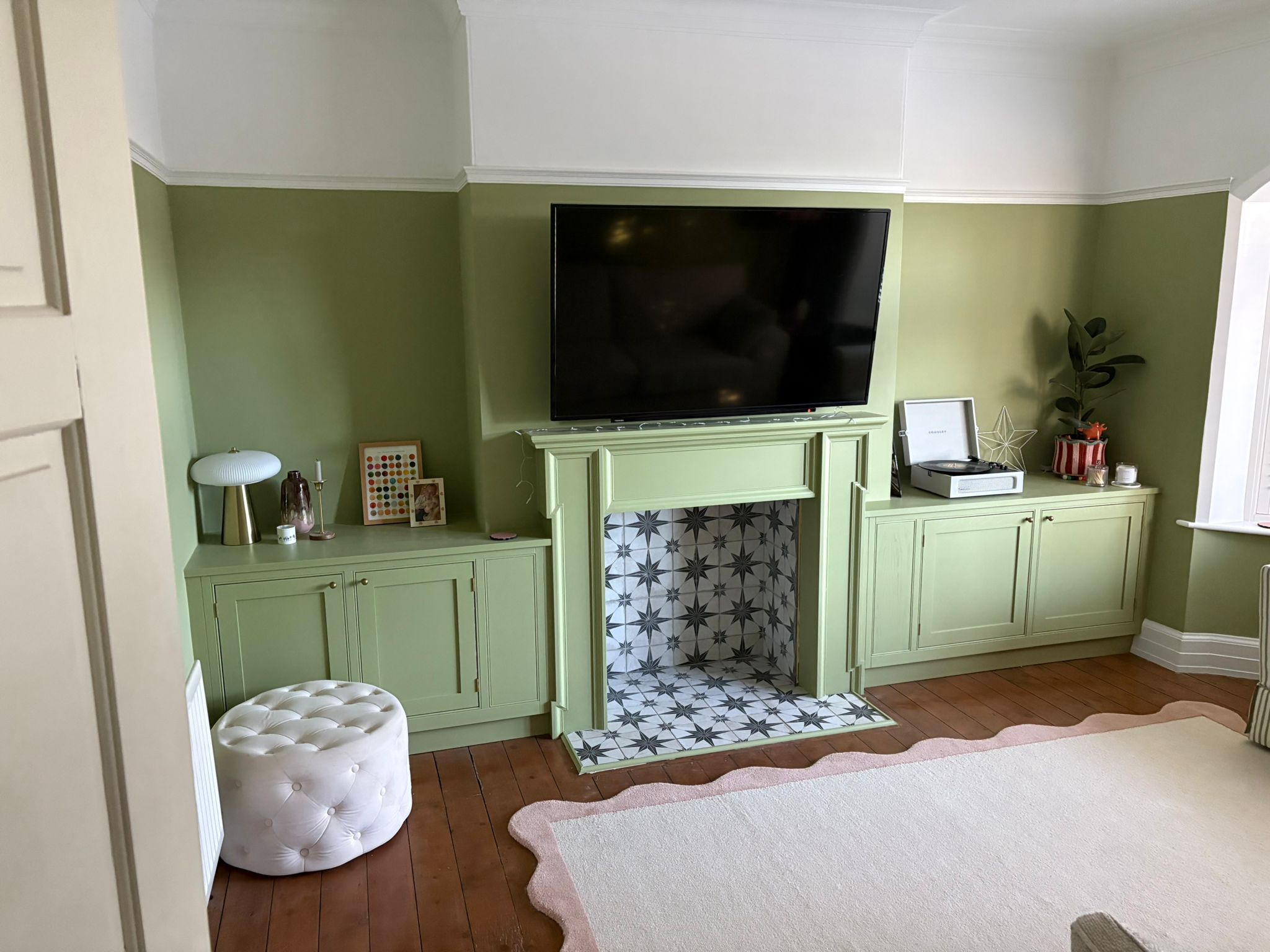 Green living room with bespoke inframe furniture and custom fireplace